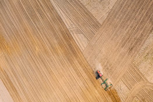 Aerial View. Tractor Plowing Field. Beginning Of Agricultural Spring Season. Cultivator Pulled By A Tractor In Countryside Rural Field Landscape.