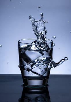 The image of pouring drinking water, into a glass, that makes one feel refreshed on blurred white background, Splashing water, Sparkling water