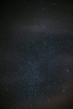 Milky Way Galaxy Glowing Through The Light Cloudiness Overcast. Real Night Sky Stars. Natural Starry Sky Dark Black Background Backdrop.
