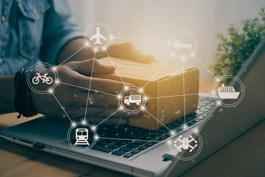 Hand of Casual Businessman or Entrepreneur Catch Parcel or Box on Laptop and Logistic or Transportation Icon. SME Online Business and E-commerce Concept for Work at Home in Vintage Tone