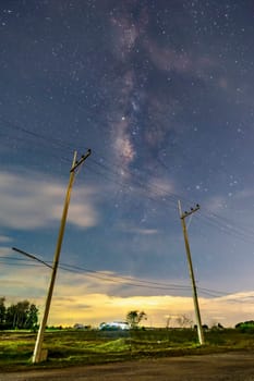 Electric poles in the nighttime countryside, the sky with stars and beautiful taro scenes, clouds below the horizon above the grass