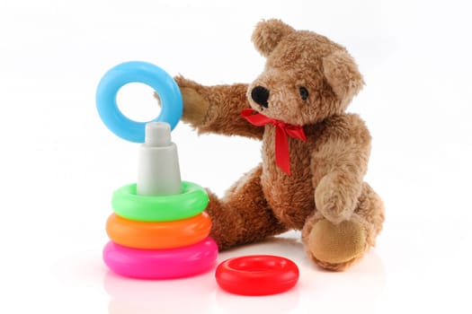 A cute teddy bear playing with toy rings