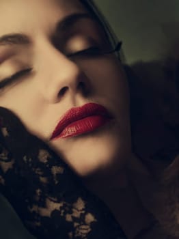 Fine art portrait of beautiful dreamy woman with fashionable makeup and red lips. Female model face closeup with luxury retro style make up and vitage laced gloves.
