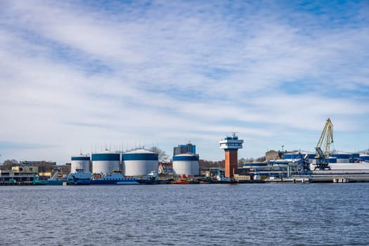 Terminal of cargo international seaport of Klaipeda, Lithuania. Cargo ship, loading and fuel tanks.