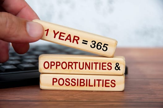 365 opportunities and possibilities text on wooden blocks on top of keyboard. Motivational concept.