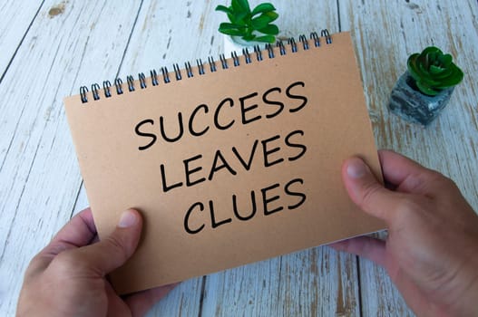Success leaves clues text written on brown notepad. Motivational and inspirational concept.