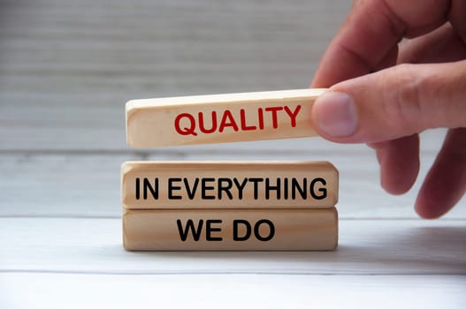 Quality in everything we do text on wooden blocks. Quality control and business concept