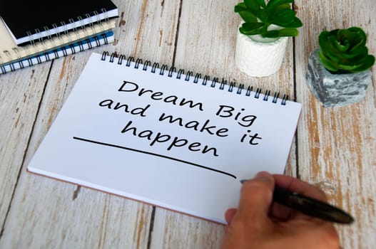 Dream big and make it happen text written on notepad. Motivational and inspirational concept.