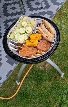Barbecue at the campground at summer camp trips, skewers of pork and beef tenderloin at barbecue party in camping, summer camp trips an activity to relax.