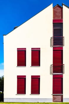 Modern House Facadewith red windows and balcony.