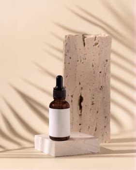 Glass cosmetic Dropper Bottle on travertine stone and palm leaf shadow on light yellow, close up, mockup. Skincare beauty product, essential oil or serum. Exotic cosmetics, pastel minimal composition..
