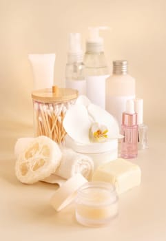 Natural cosmetic jars and skin care accesories with white orchid flower on light yellow, close up, copy space. Beauty products. Everyday woman face care routine, Spa Treatments