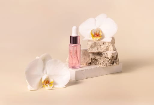 Dropper Bottle on stone near white orchid flowers on light yellow, close up, mockup. Skincare beauty product, essential oil or serum. Exotic cosmetics, pastel minimal composition..