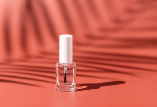 Clear Glass Refillable Bottle with Brush Cap on pink, palm leaf hard shadow, close up, mockup. Skincare or nail product. Natural cosmetics, minimal composition..