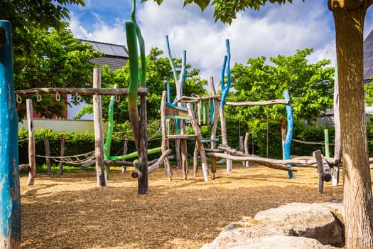 Empty public playground on sunny day with play equipments made from wood