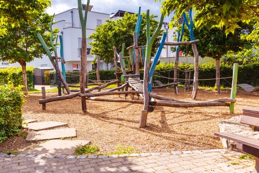 Empty public playground on sunny day with play equipments made from wood