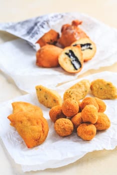 Finger food and street food - assortment of Arancini rice balls, fried curd balls, cod pies