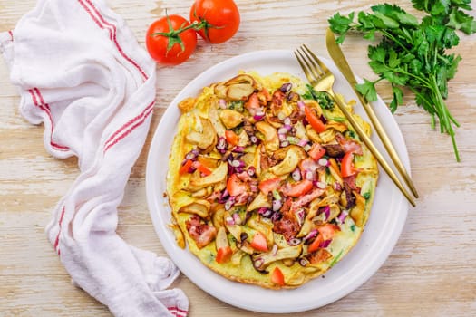 Vegetarian omelette or frittata with herbs, mushrooms, tomatoes and onion