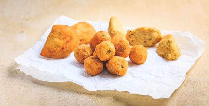 Finger food and street food - assortment of Arancini rice balls, fried curd balls, cod pies