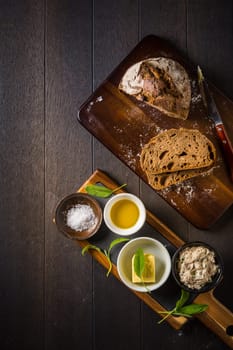 Spelt bread with homemade tuna spread, olive oil and salt on wooden background