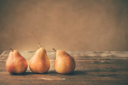 Fresh ripe pears on wooden table in vintage style. Autumn harvest.