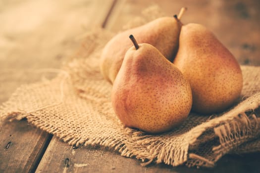 Fresh ripe pears on wooden table in vintage style. Autumn harvest.