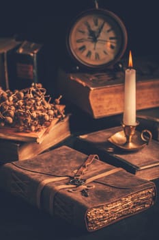 Antique leather-bound journal, book or diary with old books and candle