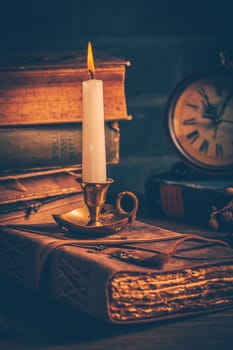Antique leather-bound journal, book or diary with old books and candle