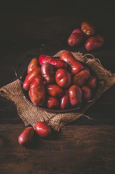 Organic raw red potatoes on wooden background