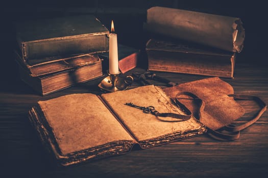 Blank antique leather-bound journal, book or diary with old books and candle