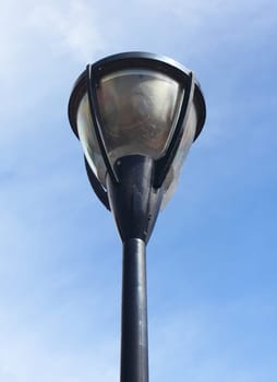 A street lamp, with blue sky in the background.Eine Straßenlaterne, mit blauem Himmel im Hintergrund.