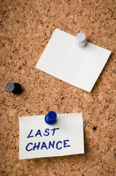 Last chance message on sticker note pin on cork office board. Reminder sign  written on card. Business concept.