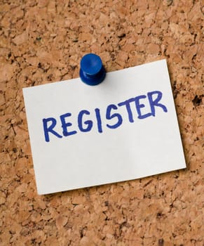 Register message on sticker note pin on cork office board. Reminder for sign up written on card. Business concept.