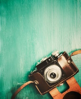 Vintage photo camera on retro mint background with copyspace.