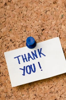 Thank you message on sticker note pin on cork office board. Business concept.