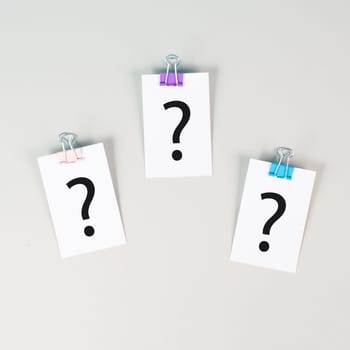 Question marks on paper, brainstorming and looking for answers, solving a problem, making a decision, business and education concept