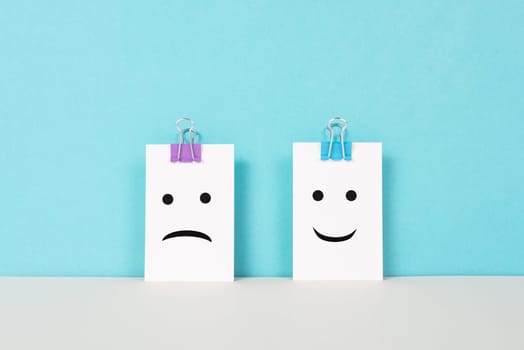 Head with a sad and a happy face, mental health concept, positive and negative mindset, depression, support and evaluation symbol, emotion