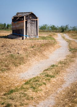 Wood destroyed hut leaning in the meadow