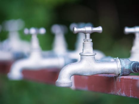 Brass water tap in nature background.