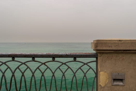 Rusted metal decorated protective fence of Stanley bridge at Alexandria, Egypt with Mediterranean Sea in the background