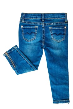 Girls jeans isolated. Folded trendy stylish female blue jeans trousers isolated on a white background. Fashionable denim pants for kids. Back view.