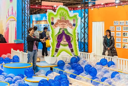 chiba, japan - december 22 2018: Woman staff of the anime convention Jump Festa 19 entertaining the area dedicating to Dragon Ball decorated with a life sized standee of the character named Broly.