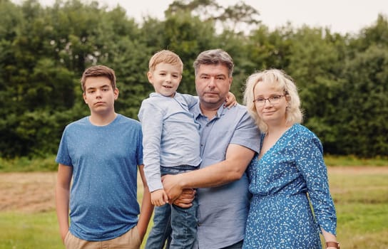Happy family standing in the natural park. Concept of family relation and love.