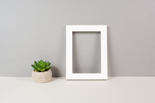 Home interior poster mock up with wooden frame, cactus in a pot, gray wall background, copy space for text and pictures
