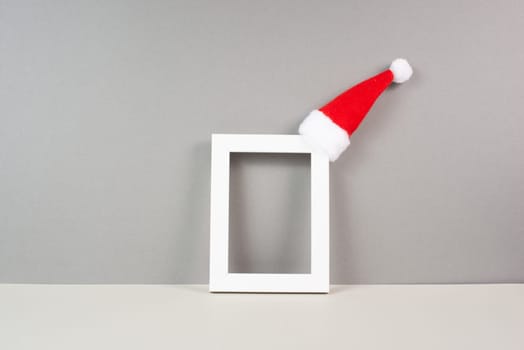 Home interior poster mock up with wooden frame, a red Santa Claus hat, greeting card for christmas, copy space for text and pictures