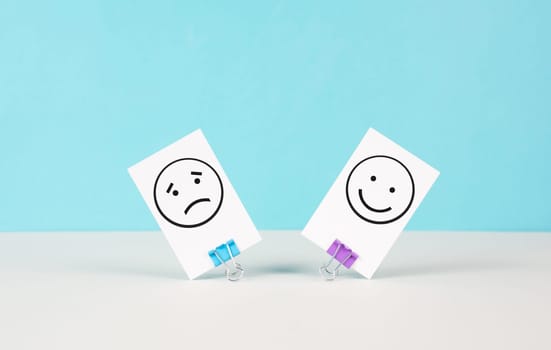 Head with a sad and a happy face, mental health concept, positive and negative mindset, depression, support and evaluation symbol, emotion