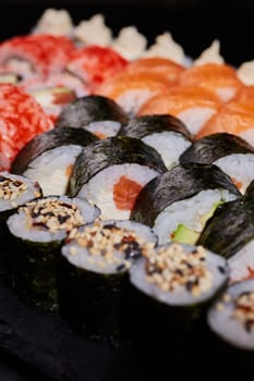 Image of a sushi set with Maki rolls in the foreground. Japanese food concept. Japanese food concept.