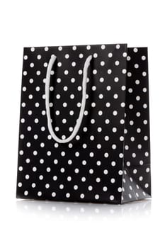 Shopping bag. Black package for shopping or gifts with white handles and dots. Concept of gifts for birthday, women's day, mother's day. Isolated on white.