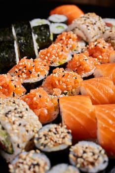 Close up of a set of sushi genera with raw salmon and sesame seeds. Japanese traditional cuisine. Selective focus.