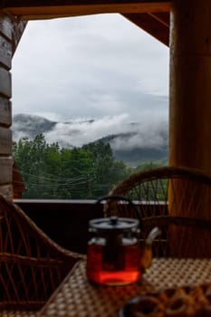 Foggy mountain landscape looking from the balcony of a resort or hotel room. Morning tea. Natural scenery background.